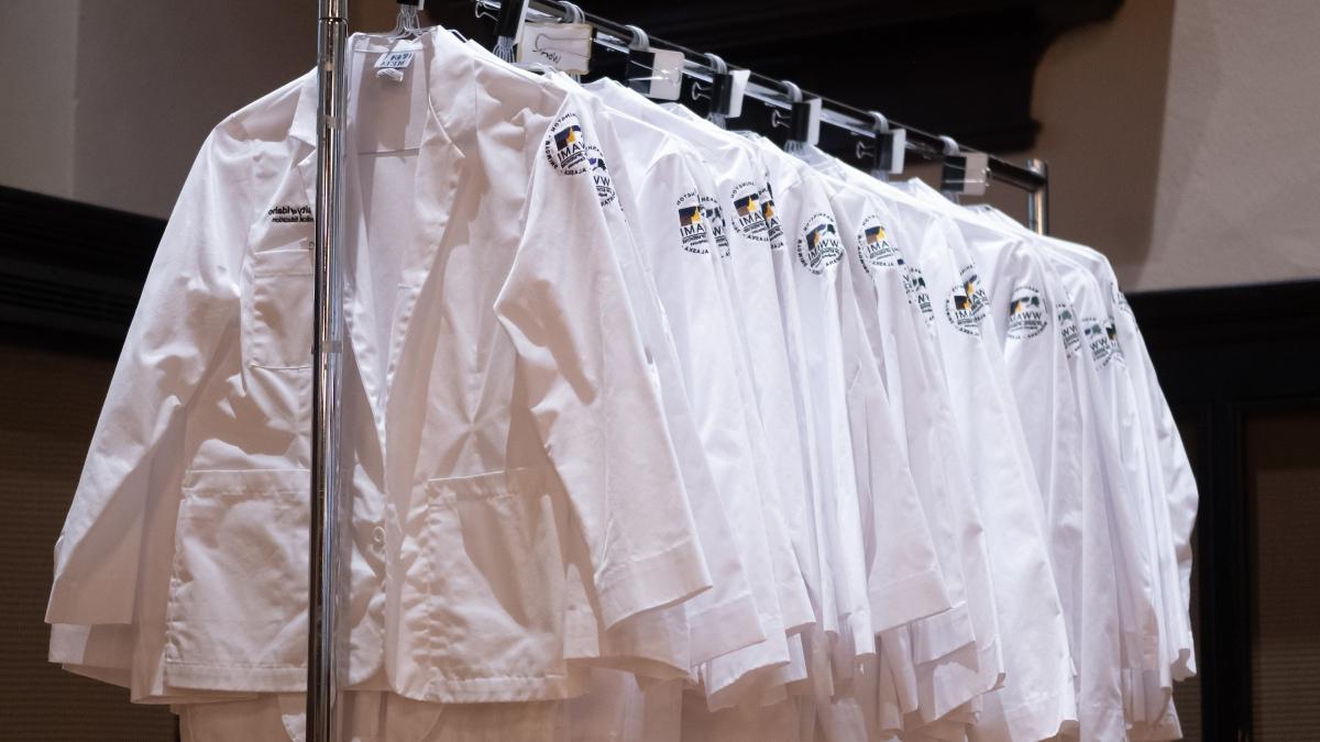 White coats hang from a bar