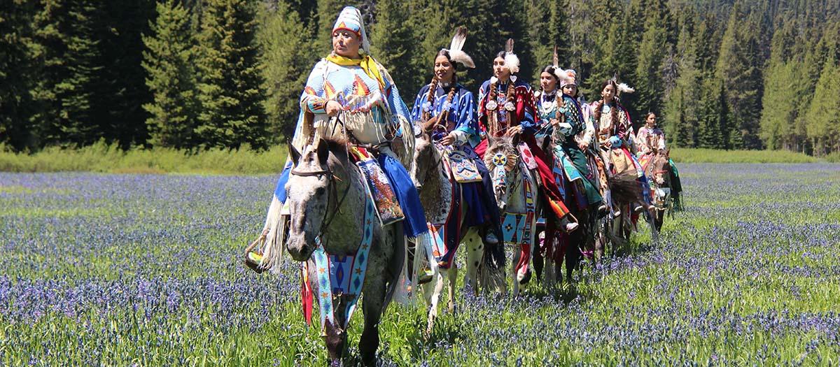 Tribe on horseback in field